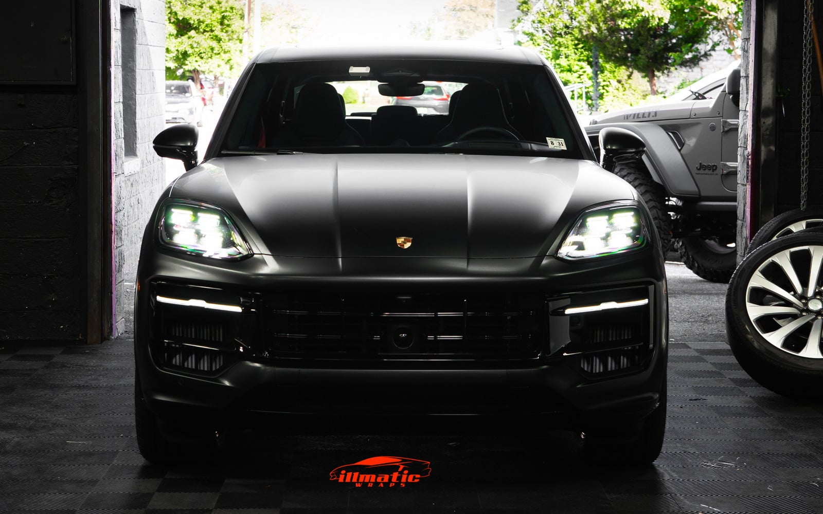 Satin black Porsche Cayenne in the illmatic Wraps bay doorway